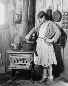 Arkansas Prints: The teenage daughter of a an impoverished Arkansas farmer cooking on an old stove while her mother was in a