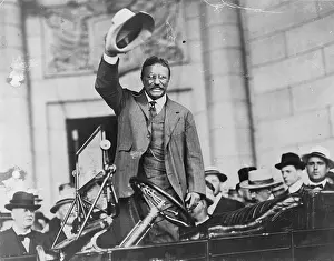 Ex Presidents Prints: Theodore Roosevelt, waving his hat, as he stands in car. Ca. 1910