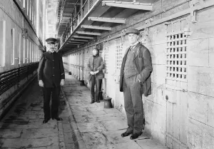 Punishment Prints: Thomas Mott Osborne (at right), Warden of Sing Sing prison in a cell block with guards