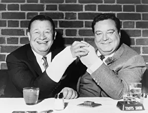 Restaurant Prints: Toots Shor and actor Jackie Gleason holding up their broken hands while lunching at Toots Shors Restaurant