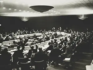 Delegates Prints: United Nations delegates, some wearing headphones with hands raised to vote