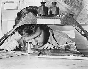 Intelligence Prints: U.S. Air Force Sergeant studies an reconnaissance photo of a Communist gun position