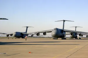 Images Dated 16th March 2011: An U.S. airman dwarfed by a C-5 Galaxy cargo aircraft signals the plane through a crowded runway at Moron Air Base