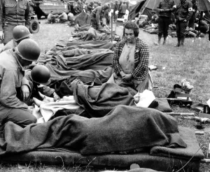War Victims Prints: Three U.S. Army medics attend to a young girl's injury on Aug