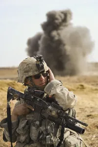 Candid Occupational Portrait Prints: U.S. Army soldier with covers his ear as a controlled detonation destroys an improvised explosive device in Badula Qulp