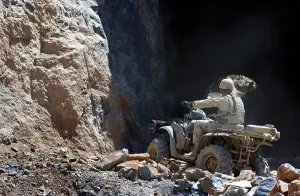 Disarmament Prints: A U.S. Army soldier rides an All Terrain Vehicle into a cave to search for munitions on the outskirts of Kabul