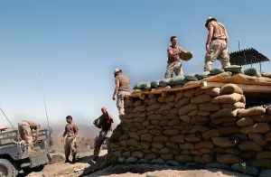 Teamwork Prints: U.S. Army soldiers of the 101st Airborne Division reinforce the roof of a forward observation post with sandbags near