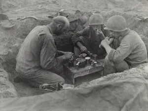 Operation Forager Prints: Three U.S. Army soldiers eat rations in a foxhole during the Battle of Saipan