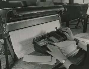Records Prints: U.S. Census worker transferring information from a questionnaire to a punch card