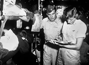 Records Prints: U.S. flight nurse checks patient records with C-54 aircraft commander Maj