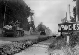 Hedgerows Prints: U.S. light tanks passing a road sign for the town of Avranches