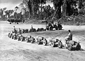 Ammunition Prints: Three U.S. Marines ride on a truck drawn bomb train at a Pacific air base
