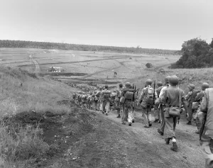U.S. Marines tired and weary from continuous fighting, march to the U.S. held valley on Guadalcanal. Jan. 1943, during World War 2. (BSLOC_2013_14_31)