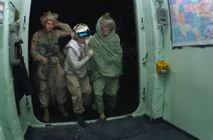 War On Terrorism Prints: U.S. Sailor and a Marine bring a wounded Pashtun fighter from Afghanistan aboard the USS Bataan for medical treatment