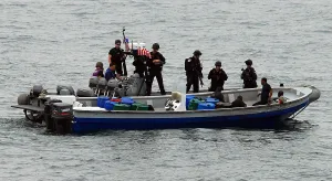 Narcotics Prints: U.S. Sailors and Coast Guardsmen question four suspected drug smugglers after their boat was intercepted in the eastern