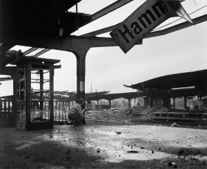 Lcgr1406 Prints: U.S. soldier crouches at the railroad station in the newly captured town of Hamm