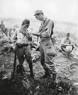 Victors Prints: U.S. soldier of lights a cigarette for a former enemy guard