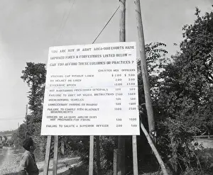 Discipline Prints: U.S. soldier reads table of crimes and fines for misconduct in Normandy