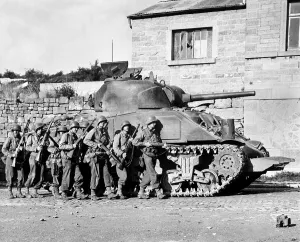Protection Prints: U.S. soldiers advance into a Belgian town under the protection of a heavy tank