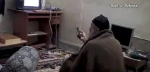 Remote Control Prints: Video still of Al Qaeda Terrorist leader Osama Bin Laden with remote control in hand while viewing himself