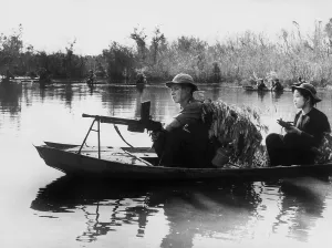 Vietnamese Prints: Viet Cong guerrillas in small boats patrol the Saigon River in South Vietnam in photo taken by communist forces