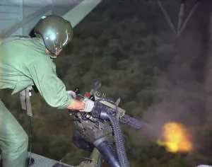 Flash Prints: Vietnam War. US Air Force helicopter door gunner fires a mini-gun during a rescue patrol over South Vietnam