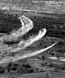 Airplane Prints: VIETNAM WAR, Crop duster airplanes spray Vietnamese countryside with napalm