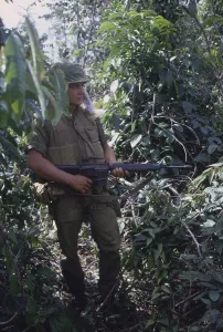 Leathernecks Prints: Vietnam War. US Marine moves through heavy grass in a deserted rice paddy while on patrol during a search