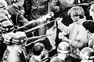 Troops Prints: Vietnam War protestor puts flowers into the barrels of soldiers rifles
