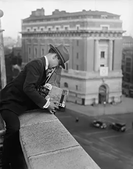 News Prints: Washington, D.C. photographer taking a picture from the roof of a building