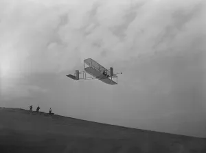 Orville Prints: Wilbur Wright pilots a glider during Wright Brothers flight experiments at Kitty Hawk