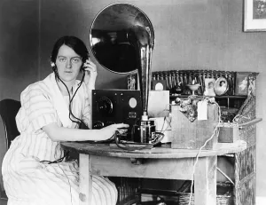 Headphones Prints: Woman listening to radio in her home receiving a personal radio message telling her when her husband will arrive home