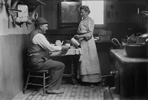 Serving Prints: Woman pouring a cup of coffee for a man at the table in Broad Channel, Queens, NYC
