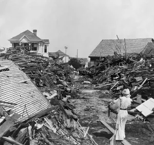 Texas Prints: A woman walks through a passageway opened in the debris, on 19th Street, Galveston, Texas