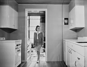 Electricity Prints: Women enters a modern 1940s kitchen with white enameled metal cabinets