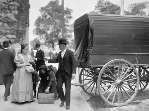 Menswear Prints: Two women immigrants and a child engage a wagon for transport to their next stop