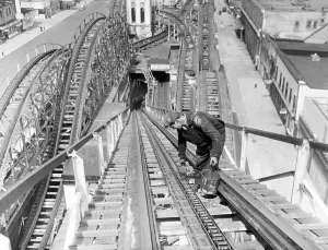 Amusement Park Prints: A workman greases up the tracks of the Cyclone roller coaster in Coney Island