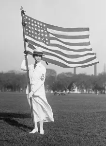 Young Adults Prints: World War 1 era US Navy Yeoman in white summer dress holding American Flag