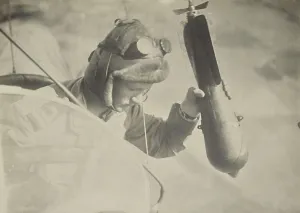 Bombs Prints: World War 1 flyer holding a bomb in his hand