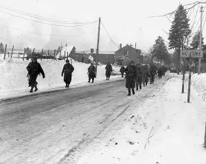 Us Army Prints: World War II. US Army infantrymen march on a road near Bastogne, Belgium. Dec 1944