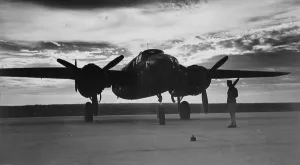 Propeller Prints: World War II, soldier beside WWII airplane at sunrise, circa early 1940s