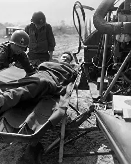 Blankets Prints: Wounded U.S. soldier lifted onto a helicopter for evacuation to a base hospital
