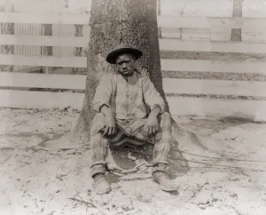 Forced Labor Prints: Young African American sitting with legs chained, Thomasville, Georgia. 1890
