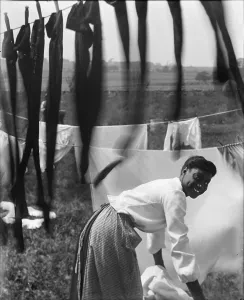 Lingerie Prints: A young African American woman working in the midst of clotheslines heavy with sheets and stockings