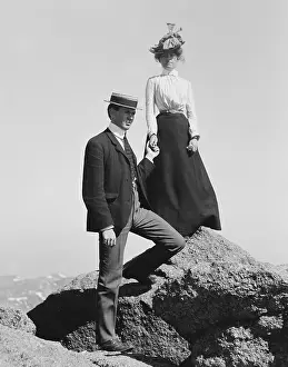 Menswear Prints: Young couple holding hands while posed on mountain rocks, c. 1900-1910 (BSLOC_2018_3_82)