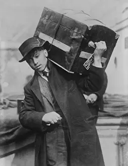 Young Man Prints: Young male immigrant carrying his trunk on his shoulder at Ellis Island