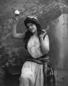 Raised Arm Prints: Young woman holding cigarette and drinking glass, photograph by Fritz W. Guerin, 1902