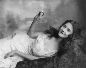 Lounging Prints: Young woman lying on a sofa and holding a burning cigarette
