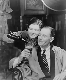 Commercial Prints: Young woman pouring beer into a man's glass, 1933
