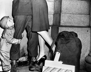 Married Prints: A youngster, clutching his soldier father's leg has lost his parents attention